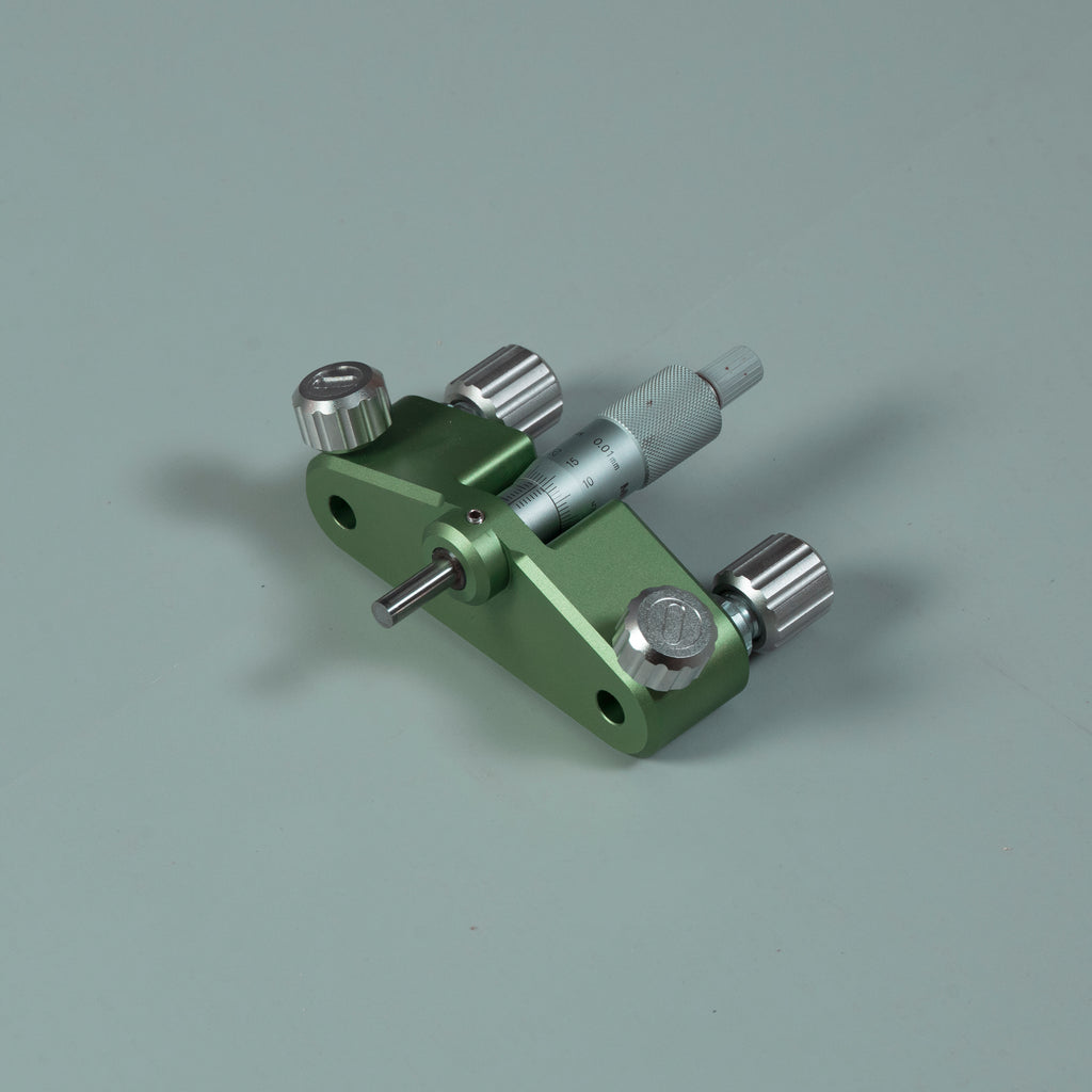 Green router circle-cutting jig with attached measuring rod and multiple metal knobs