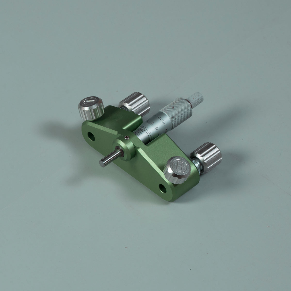 Green router circle-cutting jig with attached measuring rod and multiple metal knobs