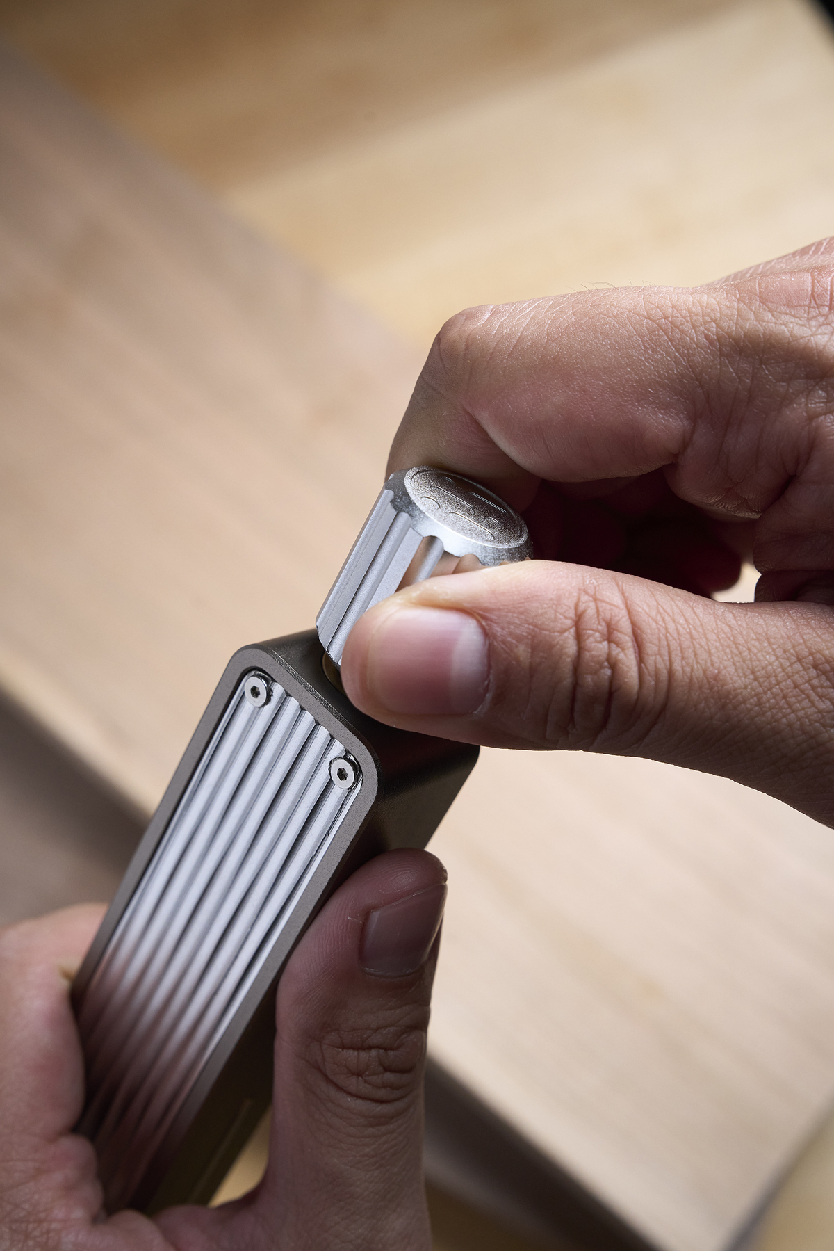 Sliding bevel gauge held by hands aligning the angled blade on wood