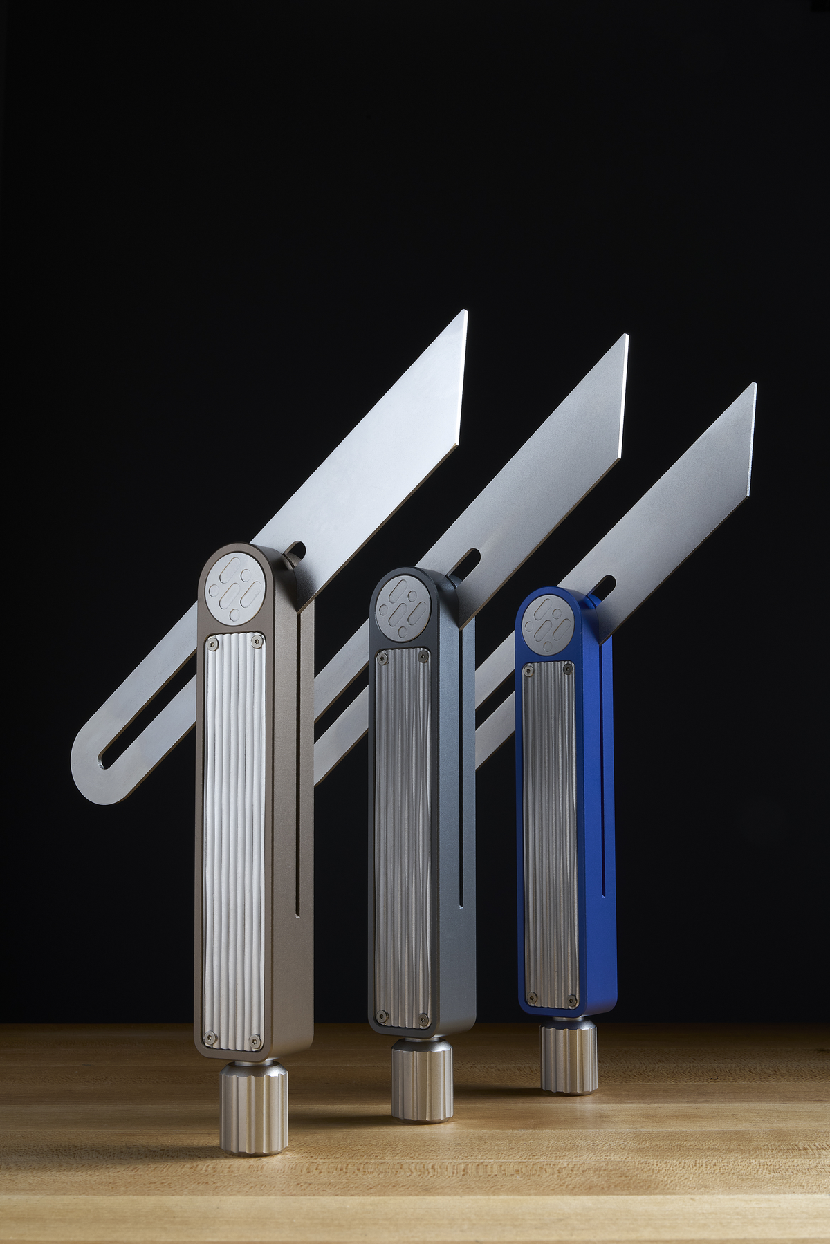 Sliding bevel gauges displayed in silver, dark gray, and blue with silver bases